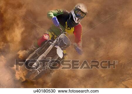 Stock Image - Young male motocross rider racing in dust. Fotosearch