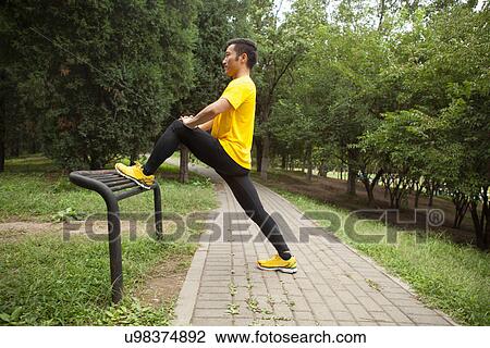 Young male runner warming up in park View Large Photo Image Stock Image - Young male runner warming up in park. Fotosearch