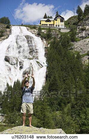 Young man taking smartphone selfie in front of Toce waterfall, Formazza, Verbania, Piemonte, Italy View Large Photo Image Stock Photo - Young man taking smartphone selfie in front of Toce waterfall, Formazza, Verbania, Piemonte, Italy. Fotosearch