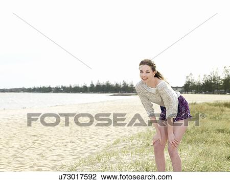 Young woman bending forwards with hands in knees View Large Photo Image Stock Image - Young woman bending forwards with hands in knees. Fotosearch