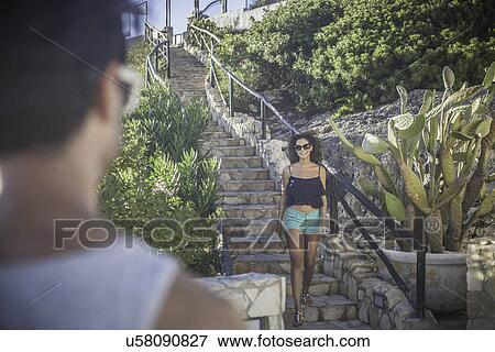 Stock Photo - Young woman coming down steps. Fotosearch