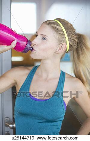Stock Photo - Young woman drinking water from bottle. Fotosearch