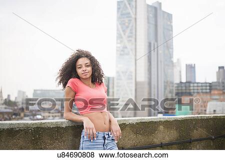 Stock Photo - Young woman leaning against wall. Fotosearch