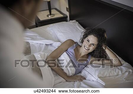 Young woman lying on bed, high angle View Large Photo Image Picture - Young woman lying on bed, high angle. Fotosearch