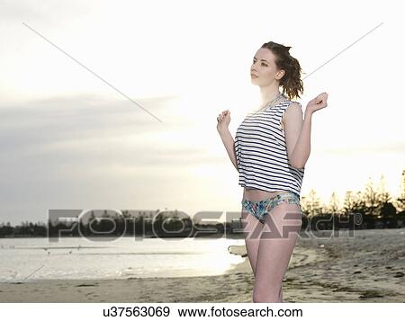 Stock Photo - Young woman on beach, dancing. Fotosearch
