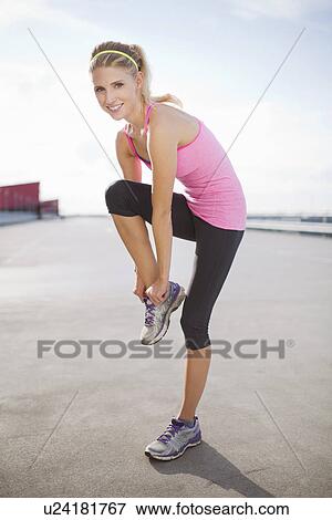 Young woman putting on trainers View Large Photo Image Stock Photo - Young woman putting on trainers. Fotosearch