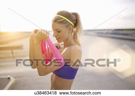 Young woman putting on vest View Large Photo Image Stock Photo - Young woman putting on vest. Fotosearch