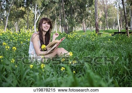 Young woman sitting in forest, reading book View Large Photo Image Stock Photography - Young woman sitting in forest, reading book. Fotosearch