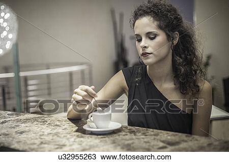 Young woman stirring coffee View Large Photo Image Stock Image - Young woman stirring coffee. Fotosearch