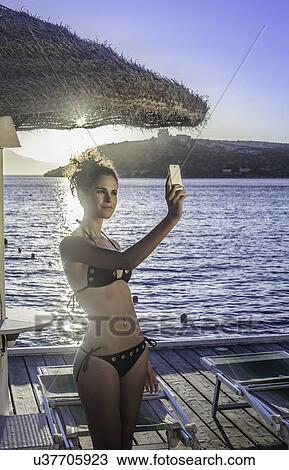 Stock Image - Young woman taking selfie on vacation. Fotosearch