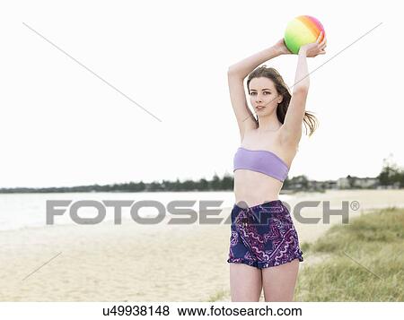 Young woman throwing beach ball View Large Photo Image Stock Photo - Young woman throwing beach ball. Fotosearch