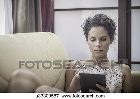 Young woman using digital tablet View Large Photo Image Stock Photo - Young woman using digital tablet. Fotosearch