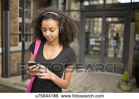 Young woman using mp3 player View Large Photo Image Stock Photograph - Young woman using mp3 player. Fotosearch