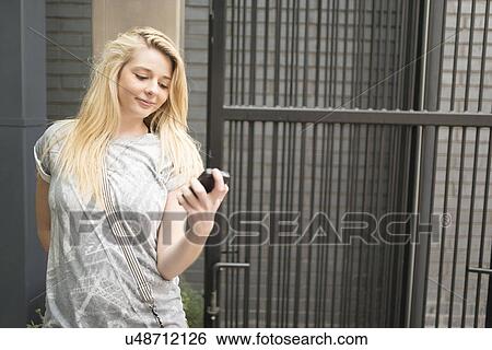 Young woman using smartphone View Large Photo Image Stock Photograph - Young woman using smartphone. Fotosearch