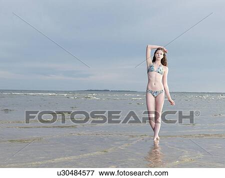 Stock Photo - Young woman wearing bikini in sea. Fotosearch