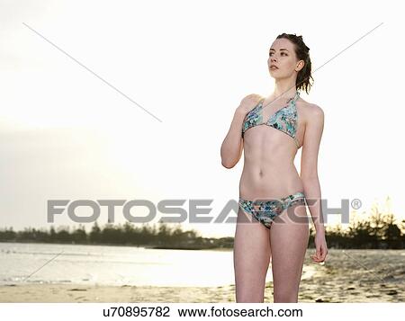 Young woman wearing bikini looking away View Large Photo Image Stock Image - Young woman wearing bikini looking away. Fotosearch