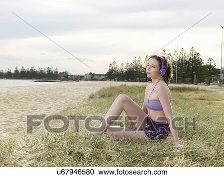 Stock Image - Young woman wearing headphones. Fotosearch