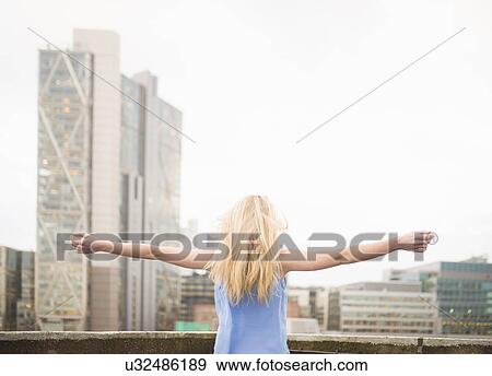 Young woman with arms outstretched, rear view View Large Photo Image Stock Photo - Young woman with arms outstretched, rear view. Fotosearch
