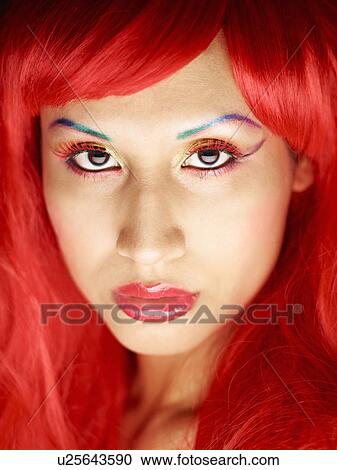 Stock Image - Young woman with dyed red hair. Fotosearch