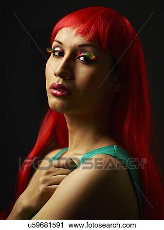 Stock Image - Young woman with dyed red hair. Fotosearch
