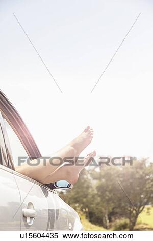 Young womans bare feet resting on car window View Large Photo Image Stock Photography - Young womans bare feet resting on car window. Fotosearch