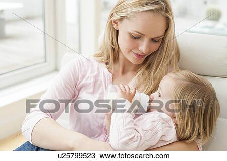 Stock Image - Mother and daughter with a bottle. Fotosearch