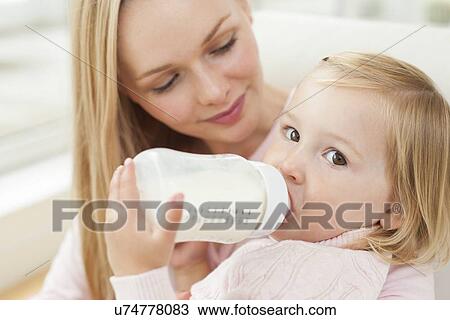 Stock Image - Mother and daughter with a bottle. Fotosearch