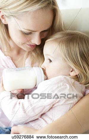 Mother feeding daughter with bottle View Large Photo Image Picture - Mother feeding daughter with bottle. Fotosearch