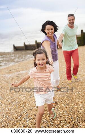 Parents running on beach with daughter View Large Photo Image Stock Image - Parents running on beach with daughter. Fotosearch