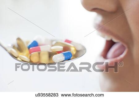 Stock Image - Woman and spoon of pills. Fotosearch