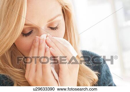 Woman blowing nose with tissue View Large Photo Image Stock Image - Woman blowing nose with tissue. Fotosearch