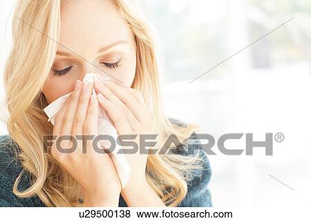 Woman blowing nose with tissue View Large Photo Image Stock Photo - Woman blowing nose with tissue. Fotosearch