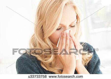 Woman blowing nose with tissue View Large Photo Image Stock Photo - Woman blowing nose with tissue. Fotosearch