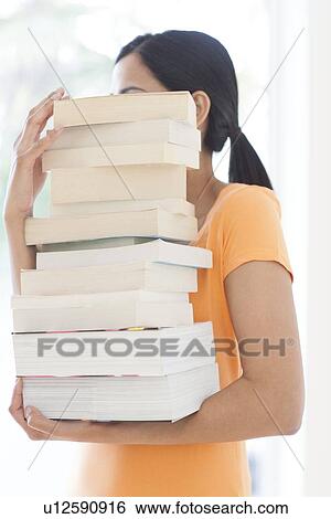 Woman carrying a pile of books View Large Photo Image Stock Photograph - Woman carrying a pile of books. Fotosearch