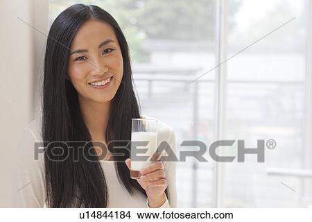 Picture - Woman holding glass of milk. Fotosearch