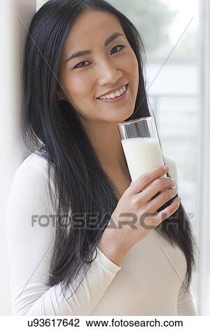 Stock Image - Woman holding glass of milk. Fotosearch