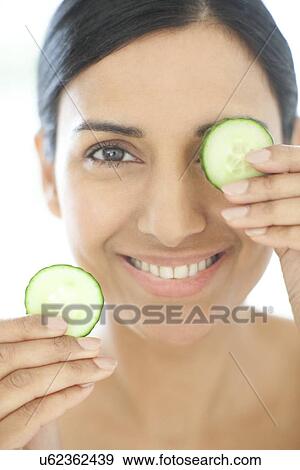 Woman holding slices of cucumber View Large Photo Image Stock Photo - Woman holding slices of cucumber. Fotosearch
