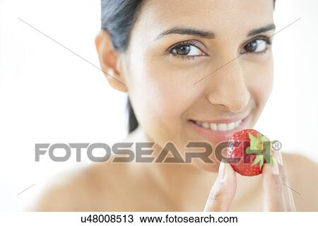 Stock Image - Woman holding strawberry. Fotosearch