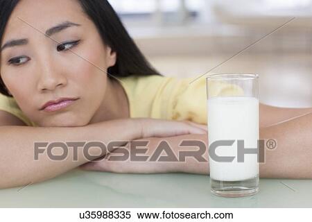 Woman looking sad with glass of milk View Large Photo Image Stock Photography - Woman looking sad with glass of milk. Fotosearch