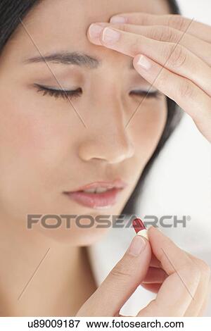 Stock Photo - Woman taking painkiller. Fotosearch