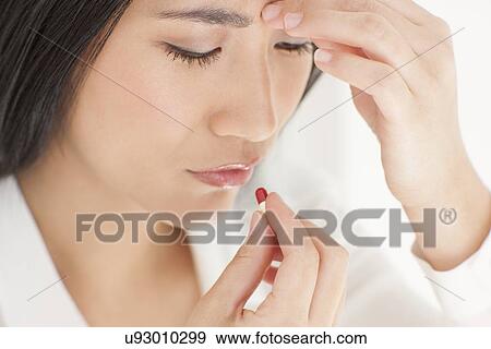 Stock Photo - Woman taking painkiller. Fotosearch