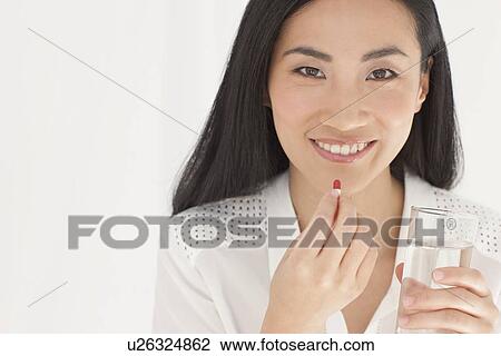 Stock Image - Woman taking tablet. Fotosearch