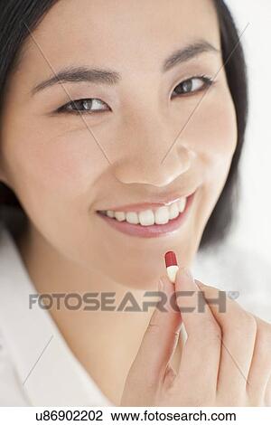 Stock Image - Woman taking tablet. Fotosearch