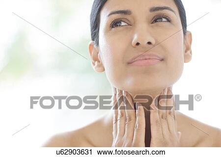 Stock Image - Woman touching her neck. Fotosearch