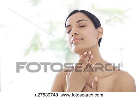 Woman touching her neck View Large Photo Image Stock Photo - Woman touching her neck. Fotosearch
