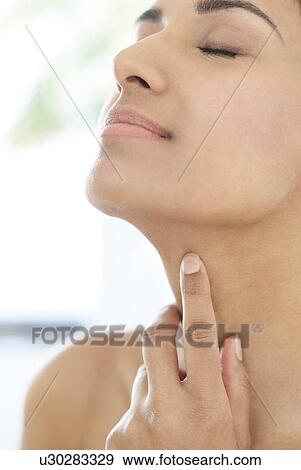 Stock Photo - Woman touching her neck. Fotosearch
