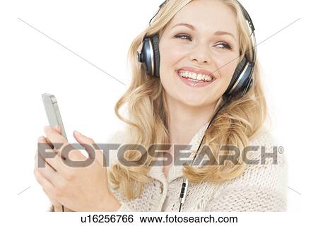 Woman wearing headphones holding smartpho View Large Photo Image Stock Photograph - Woman wearing headphones holding smartpho. Fotosearch