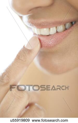 Stock Photo - Woman with her finger on her lip. Fotosearch