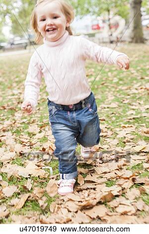 Young girl running in the leaves View Large Photo Image Stock Photo - Young girl running in the leaves. Fotosearch