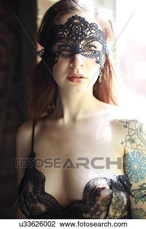 Stock Image - Tattooed woman with a mask. Fotosearch